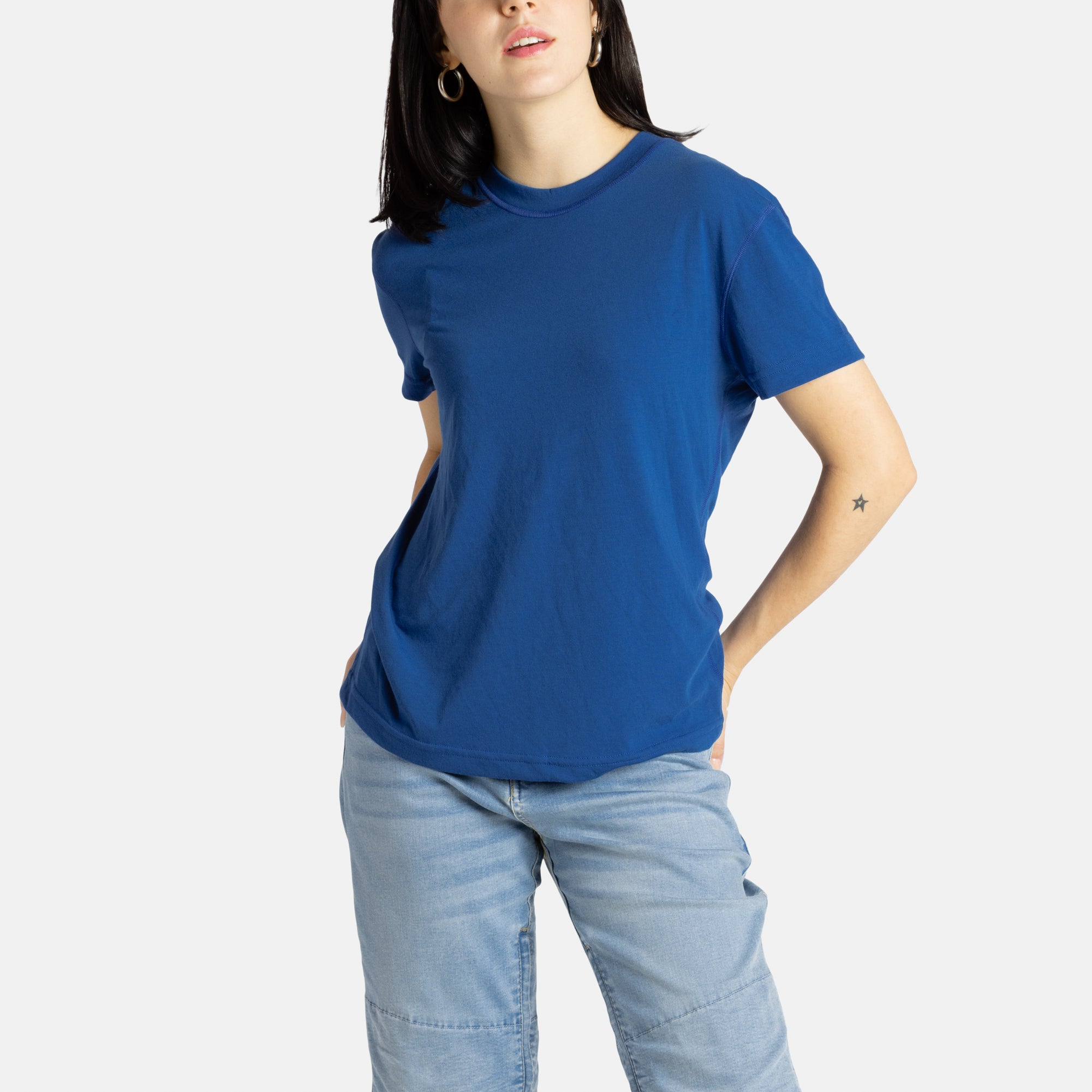 Sophia (A woman with long black hair) wears the No Limbits Adaptive Women's Navy Sensory Tee.