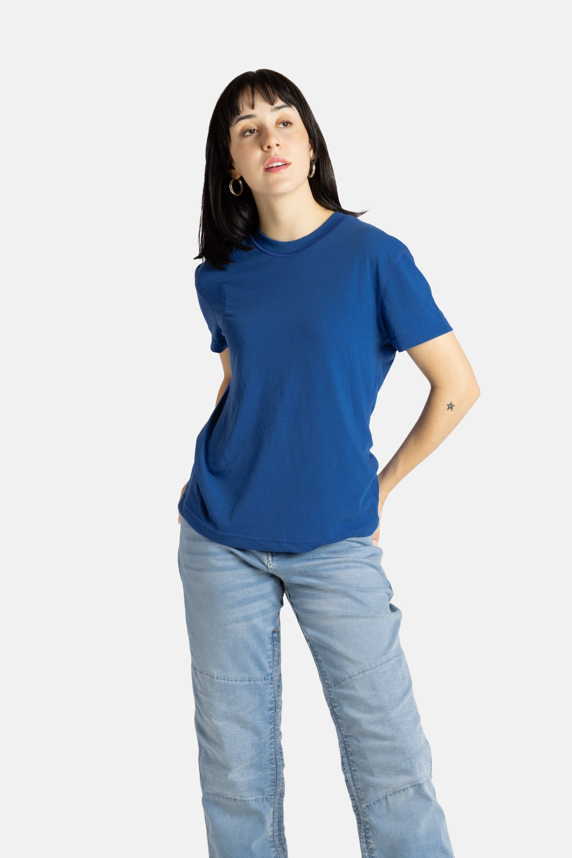 Sophia (A woman with long black hair) wears the No Limbits Adaptive Women's Navy Sensory Tee.