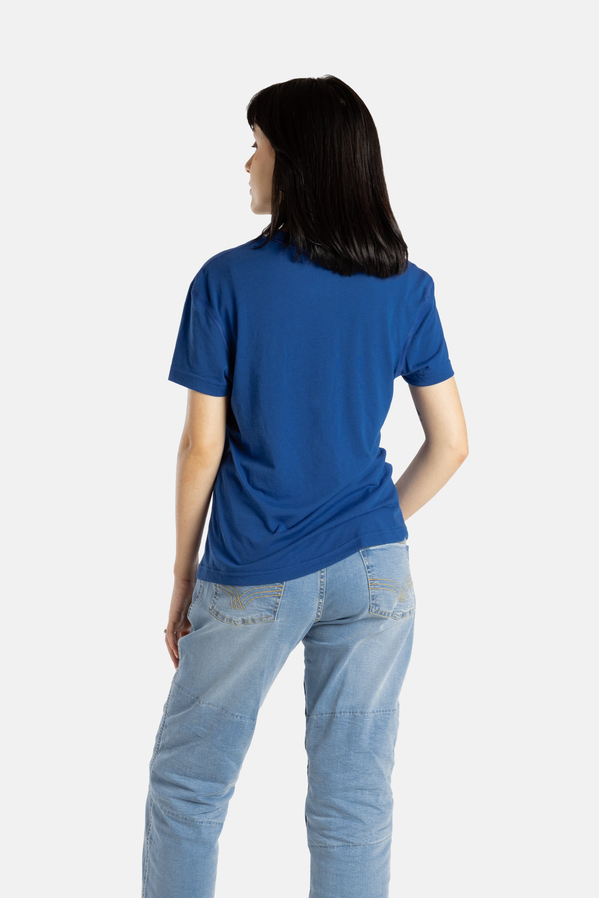 The back of Sophia (A woman with long black hair) wearing the No Limbits Adaptive Women's Navy Sensory Tee.