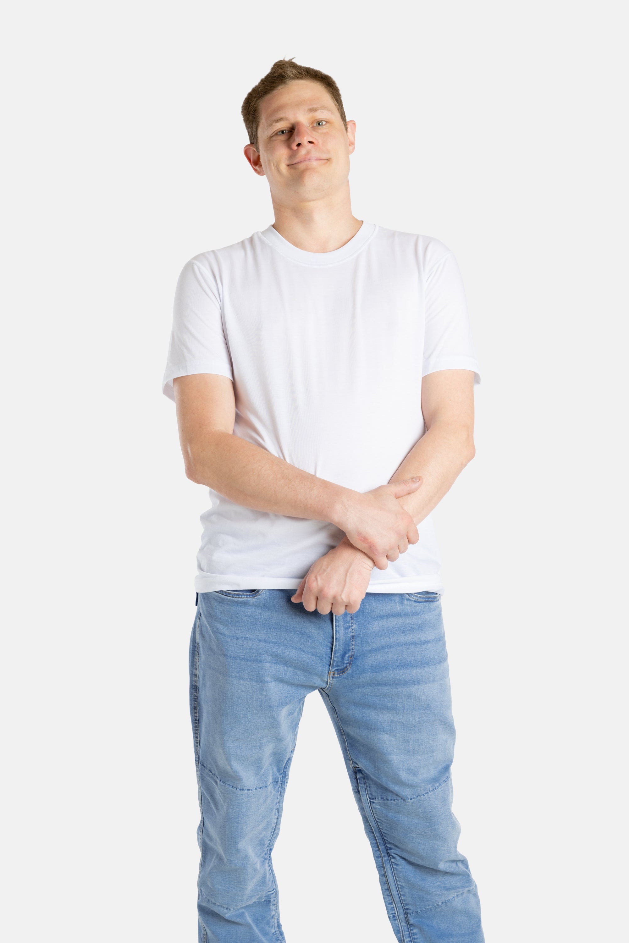 A white man with short brown hair wears a white t-shirt.