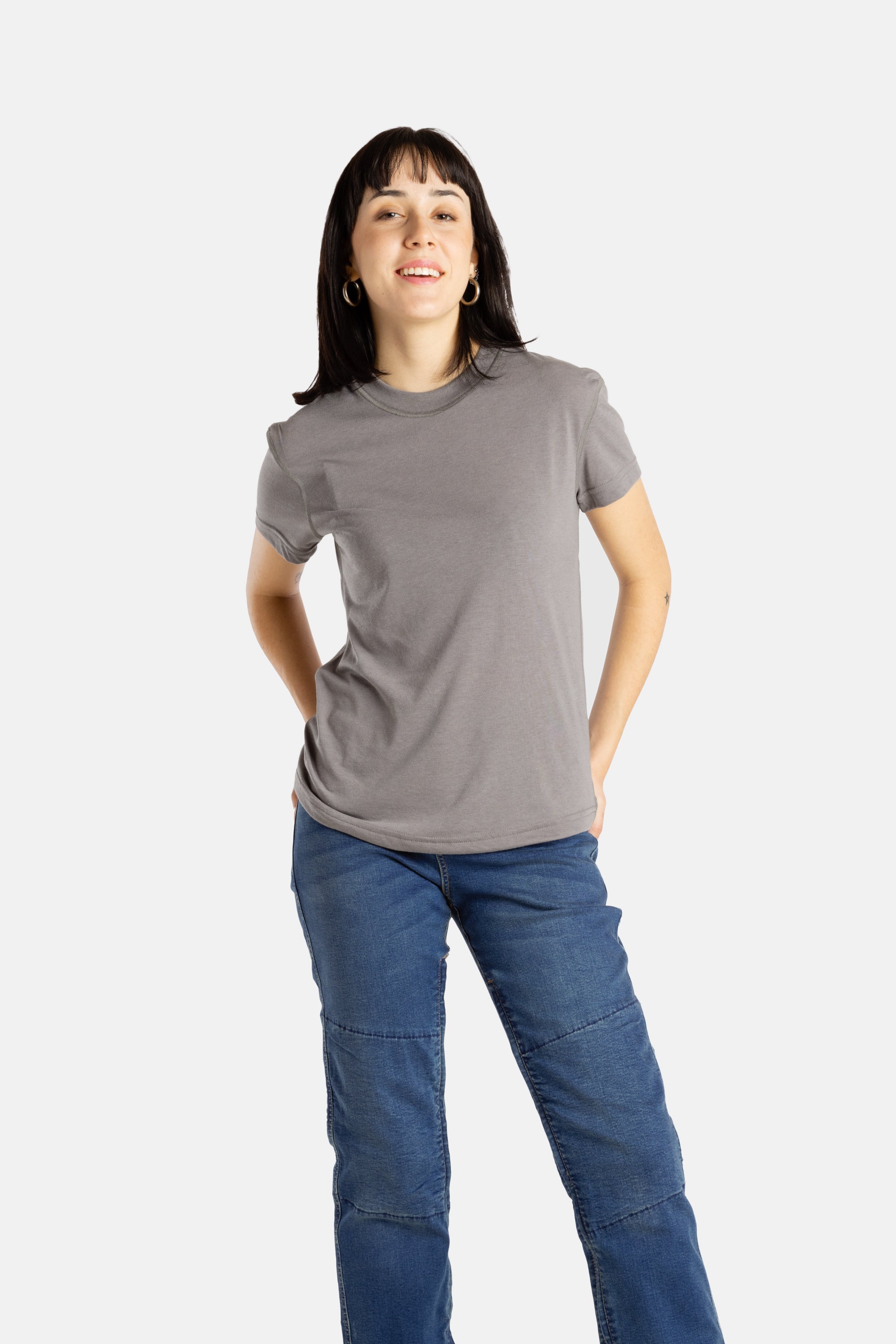 Sophia (A woman with long black hair) wears the No Limbits Adaptive Women's Charcoal Sensory Tee.