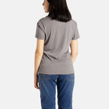 The back of Sophia (A woman with long black hair) wearing the No Limbits Adaptive Women's Charcoal Sensory Tee.
