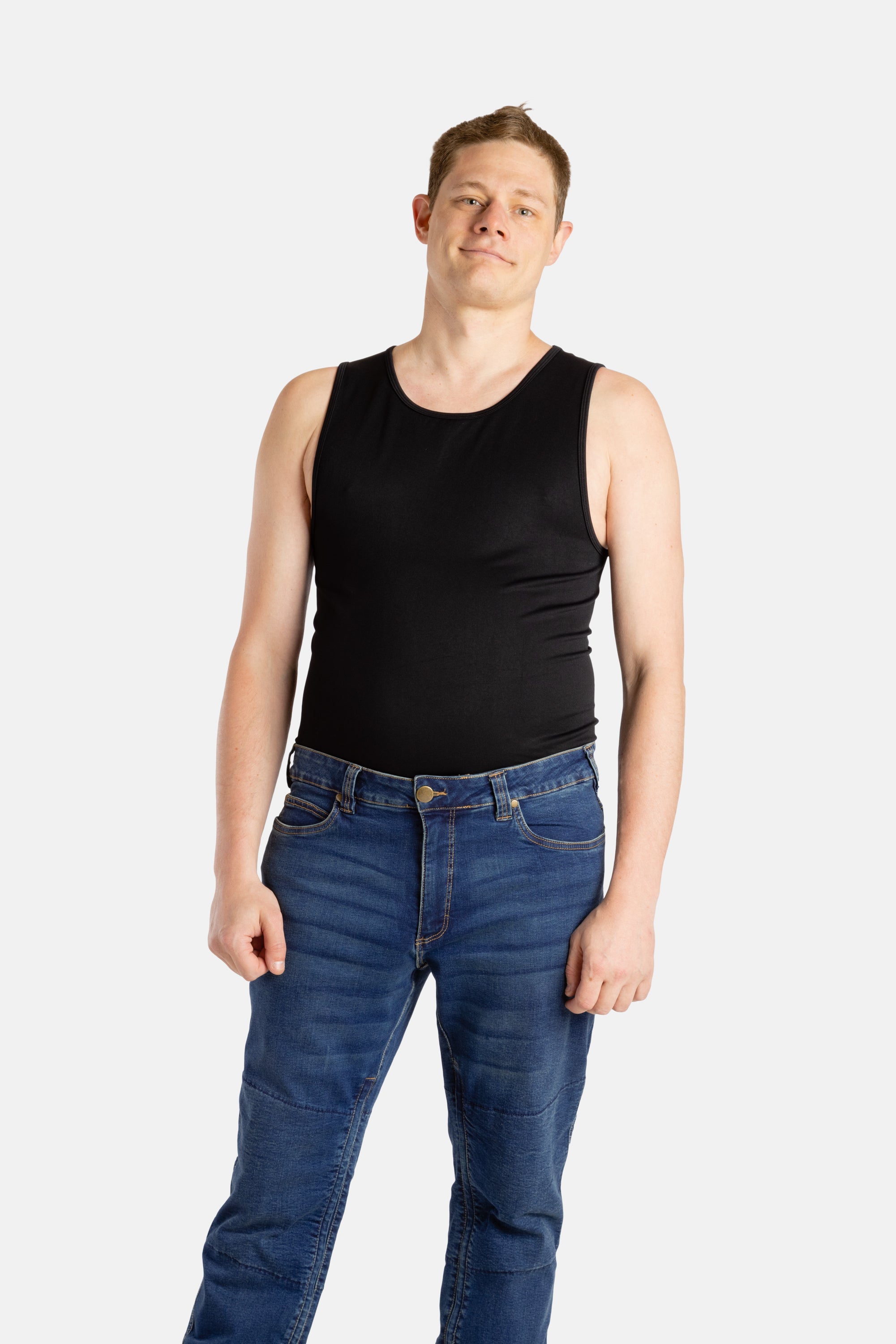 A white man with short brown hair wears a black tank top and denim jeans.