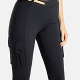 The close up of the black leggings. A hand is in the loop on the top of the pants.