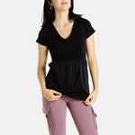 Sophia (A woman with long black hair) is wearing the No Limbits Adaptive Women's Black Sensory Blouse with mauve leggings.