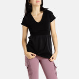Sophia (A woman with long black hair) is wearing the No Limbits Adaptive Women's Black Sensory Blouse with mauve leggings.