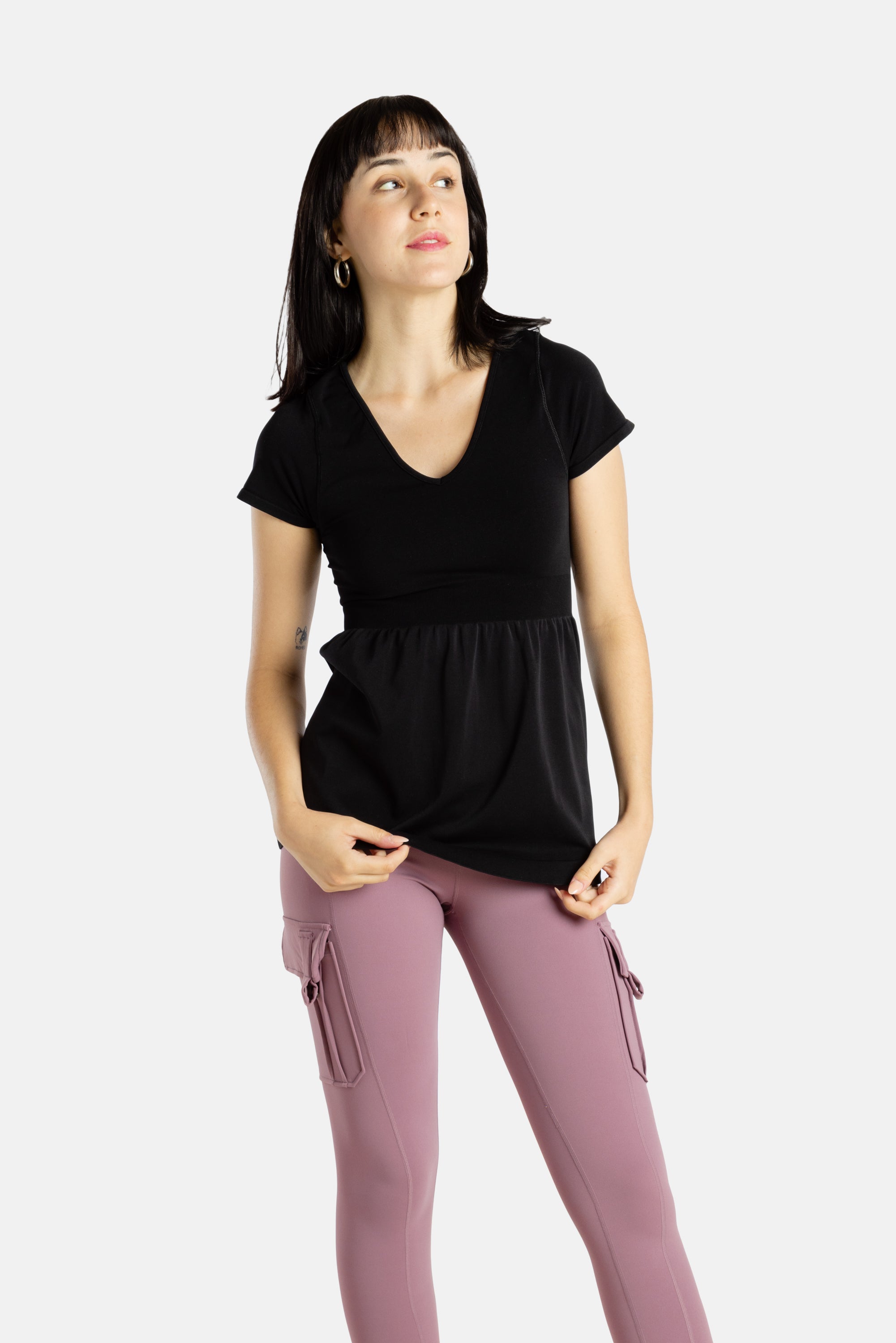 Sophia (A woman with long black hair) is wearing the No Limbits Adaptive Women's Black Sensory Blouse with mauve leggings.