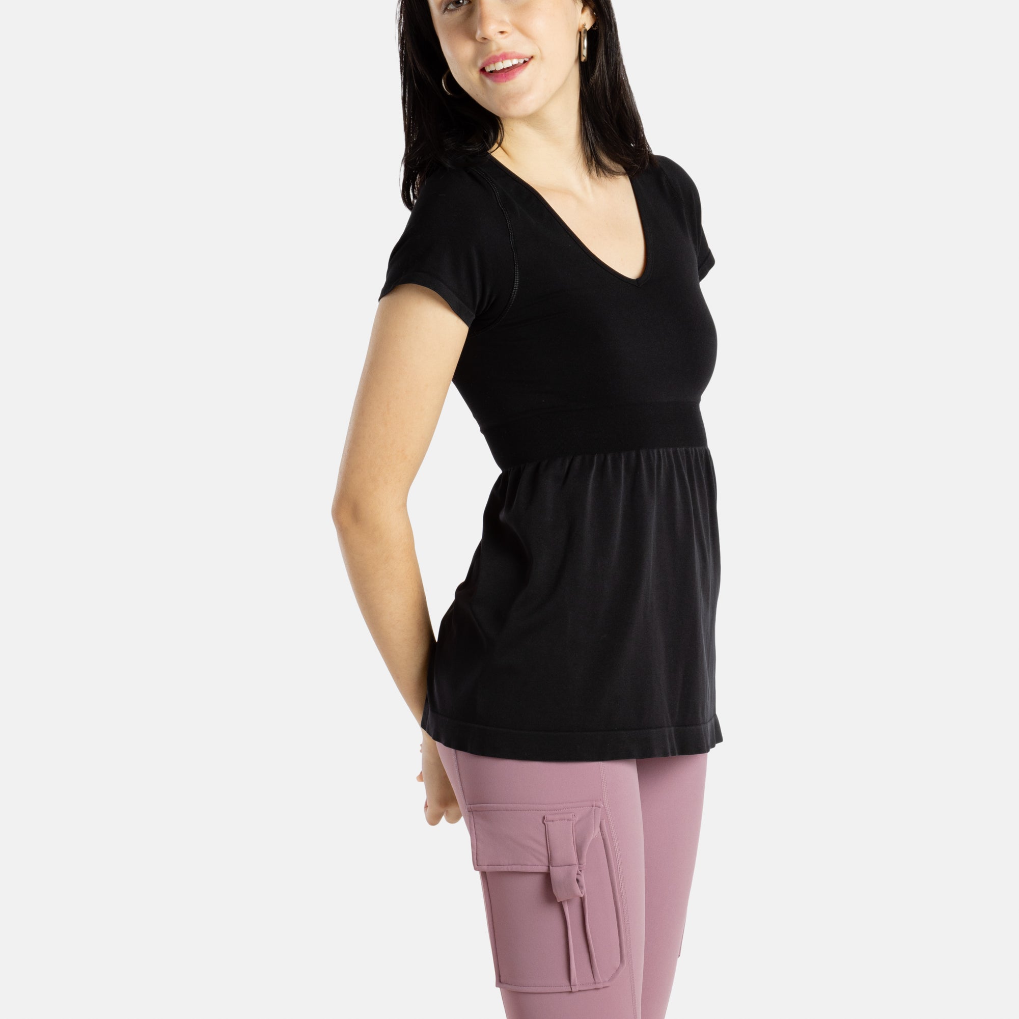 Sophia (A woman with long black hair) is wearing the No Limbits Adaptive Women's Black Sensory Blouse with mauve leggings.