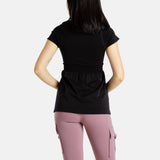 The back of Sophia (A woman with long black hair),wearing the No Limbits Adaptive Women's Black Sensory Blouse with mauve leggings.