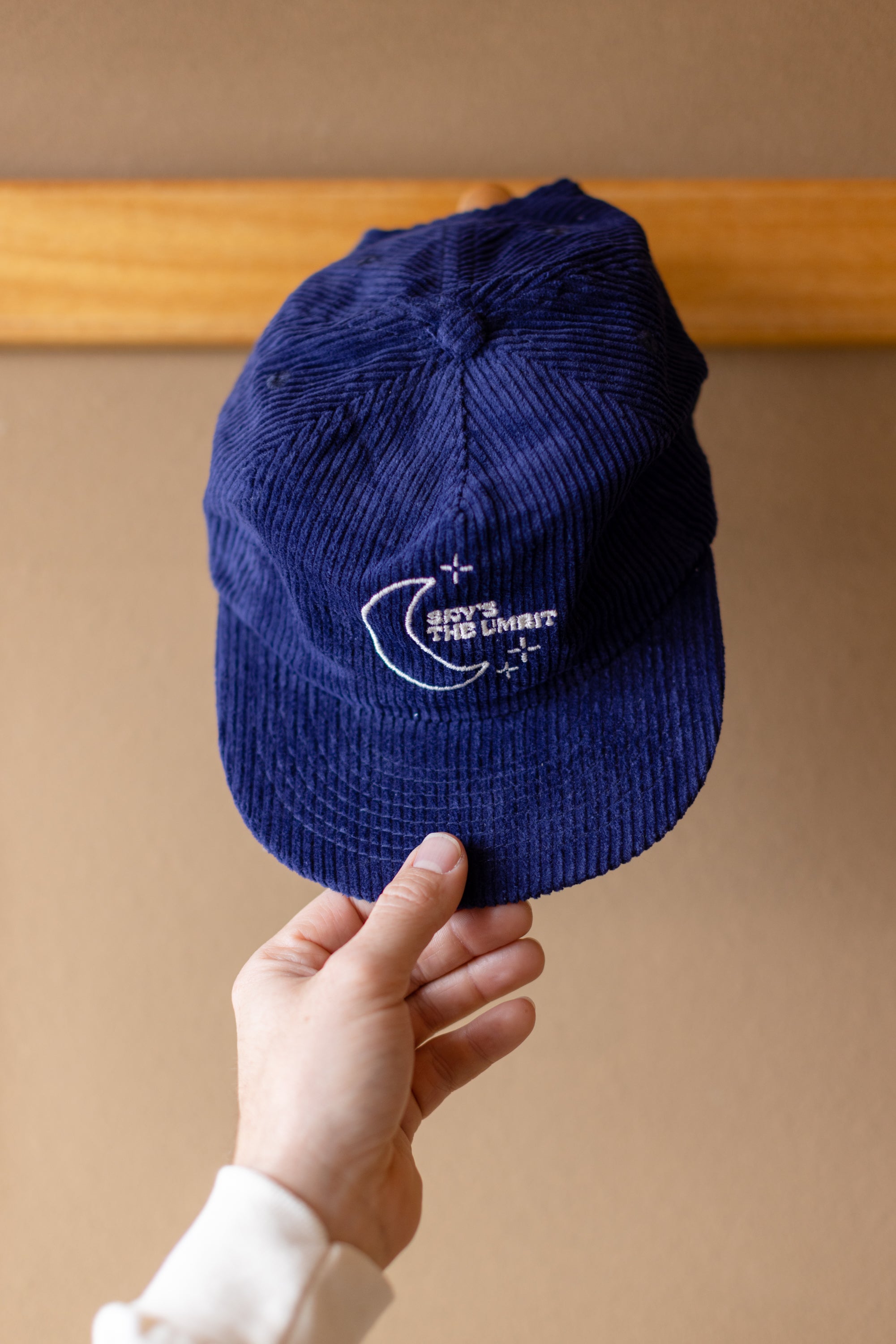 Someone puts the "Sky's the Limbits" hat on a hook.