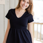 A white woman with long blonde hair is wearing the No Limbits Adaptive Women's Black Sensory Blouse.