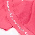 A seam of the shirt has gray words that say "You Matter - Sky's the Limbit - Not All Disabilities are Visual."