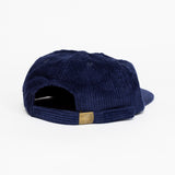 The back of a dark blue baseball cap that has a illustration of the moon and the stars that says in white font "Sky's the Limbit."