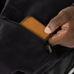 The user takes out their wallet from the pocket.