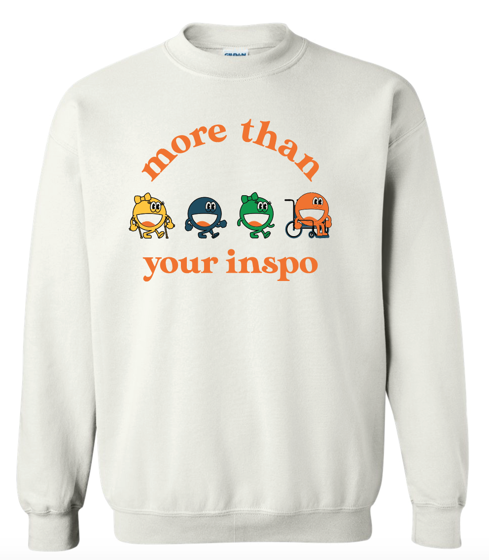 A white sweater that says “not your inspo with the four No Limbits crew members (Colorful circles with forearm crutches, a prosthetic leg, and a wheelchair.