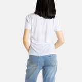 The back of Sophia (A woman with long black hair) wearing the No Limbits Adaptive Women's White Sensory Tee.