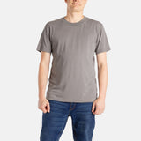 A white man with short brown hair wears a charcoal t-shirt.