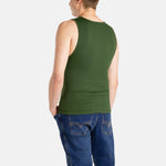 The back of a white man with short brown hair wearing an olive-green tank top and denim jeans.