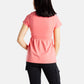 The back of Sophia (A woman with long black hair), wearing the No Limbits Adaptive Women's Coral Sensory Blouse with black leggings.