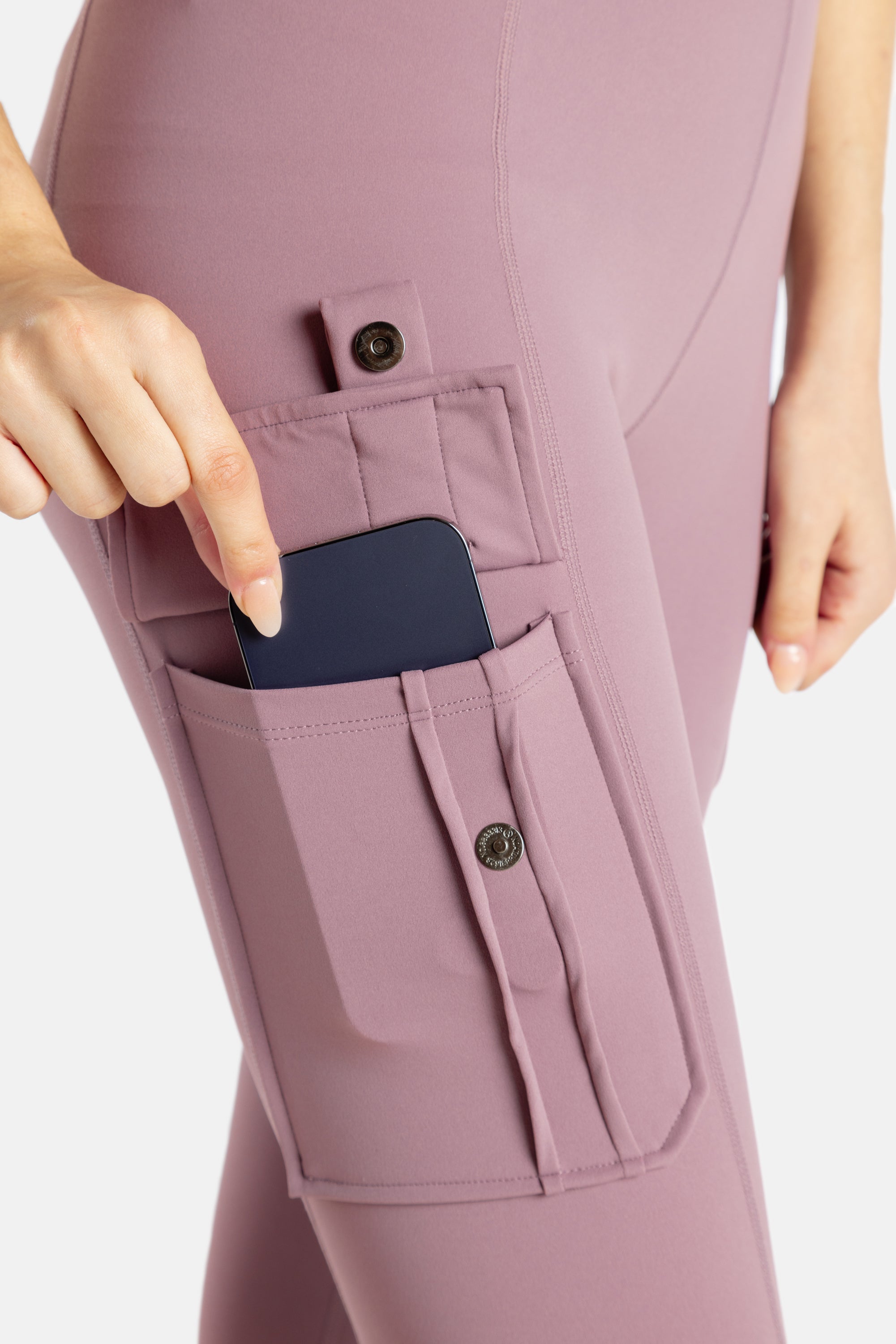 The close up of the pockets of the mauve (Pink-lavender) leggings. It's a buttoned pocket that you snap and your phone can fit.