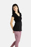 Sophia (A woman with long black hair) is wearing the No Limbits Adaptive Women's Black Sensory Blouse with mauve leggings.