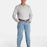 A white, elderly man with a mustache wears the Men’s Light Wash Unlimbited Pants, with a long-sleeved gray shirt, a brown belt, and brown shoes.
