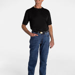 A white, elderly man with a mustache wears the No Limbits Adaptive Men's Dark Wash Unlimbited Pants (which looks like denim jeans), with a black shirt, a brown belt, and brown shoes.