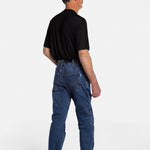 The back of a white, elderly man with a mustache wearing the No Limbits Adaptive Men's Dark Wash Unlimbited Pants (which looks like denim jeans), with a black shirt, a brown belt, and brown shoes.