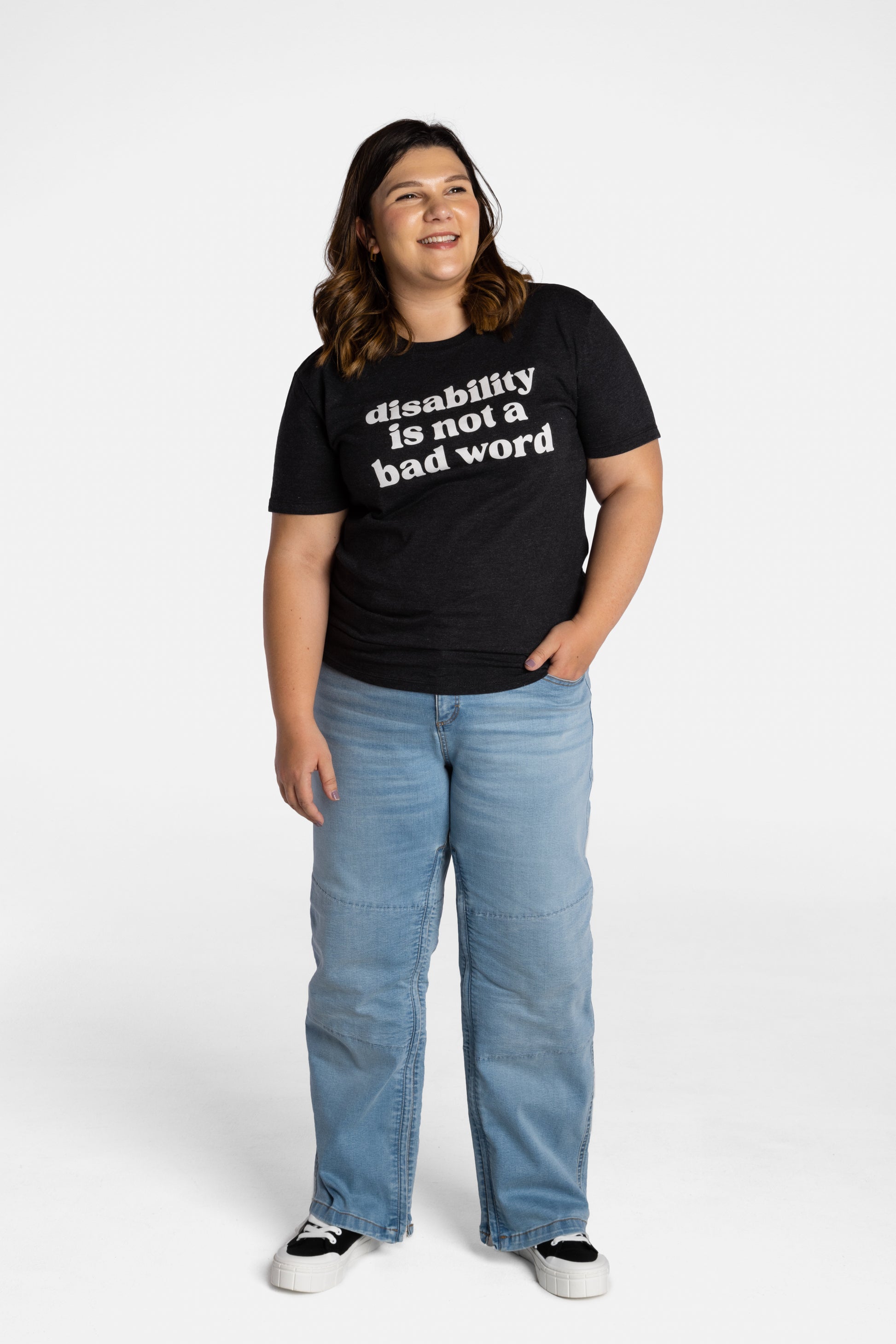 Erica Cole, the founder of No Limbits, wears the No Limbits Adaptive Women's Light Wash Unlimbited Pants. She's wearing the black "disability is not a bad word" T-shirt.