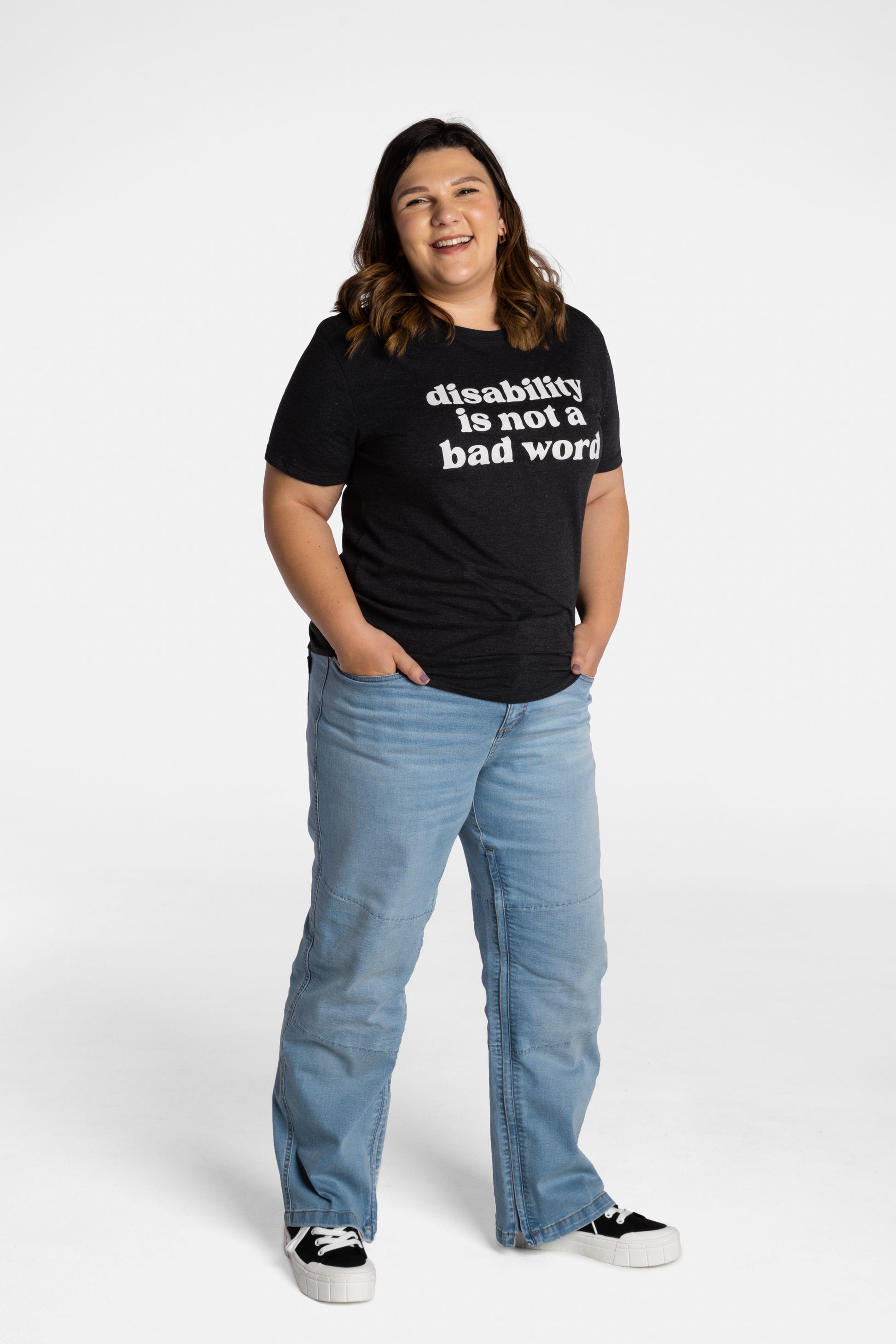 Erica Cole, the founder of No Limbits, wears the No Limbits Adaptive Women's Light Wash Unlimbited Pants. She's wearing the black "disability is not a bad word" T-shirt.