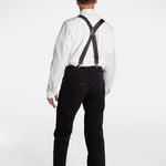 The back of a white, elderly man, wearing the No Limbits Adaptive Men's Black Unlimbited Pants, with a white shirt, brown suspenders, and brown shoes.