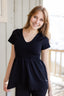 A white woman with long blonde hair is wearing the No Limbits Adaptive Women's Black Sensory Blouse.