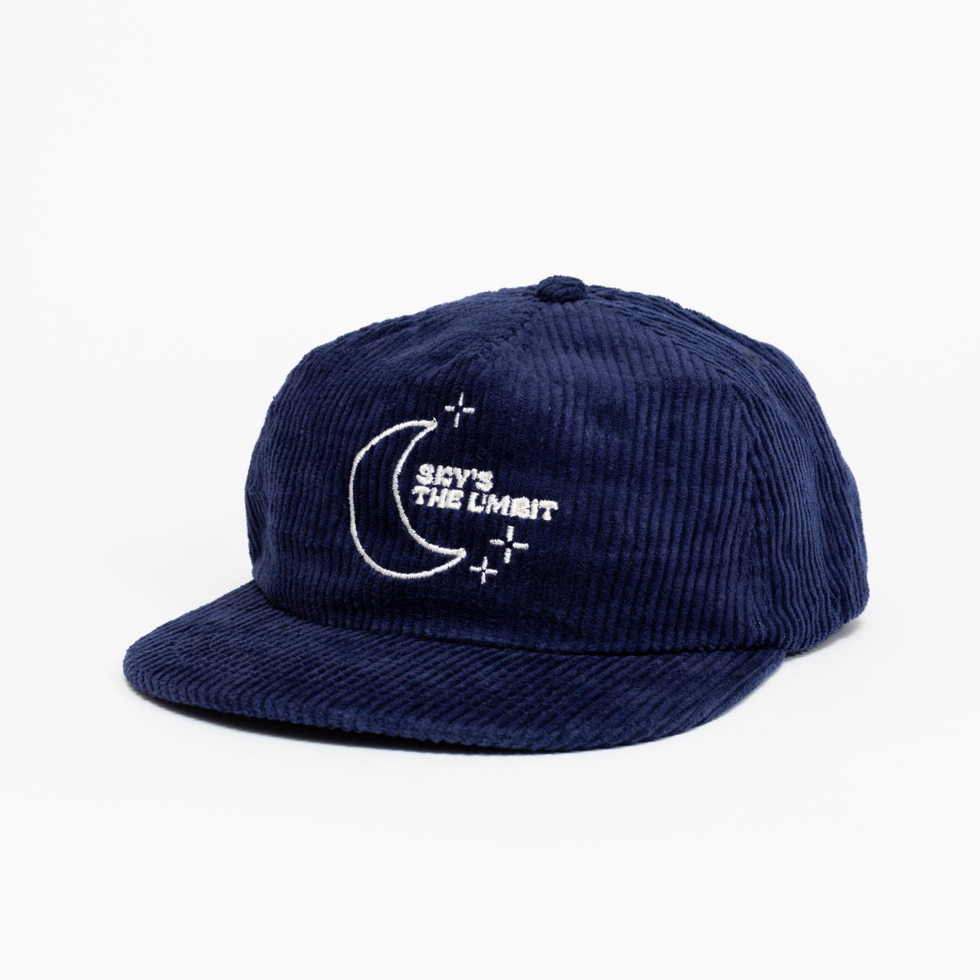A dark blue baseball cap that has a illustration of the moon and the stars that says in white font "Sky's the Limbit."